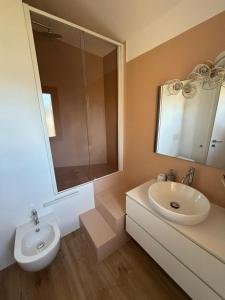 Un baño blanco con lavabo y espejo. en Attico zona mare, en Cattolica 8 fotos más