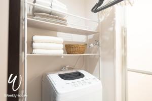 una piccola lavanderia con lavatrice e asciugatrice di WeeklyHouse Schildkrote a Otsu