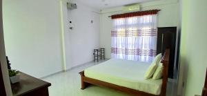 a bedroom with a bed and a window at Ambalangoda Villa in Ambalangoda