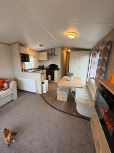a living room with a couch and a table at Stunning Clearwater Lake View Caravan in Crowle