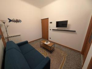 een woonkamer met een blauwe bank en een tv bij La Casa Al Mare in Vado Ligure +8 foto's