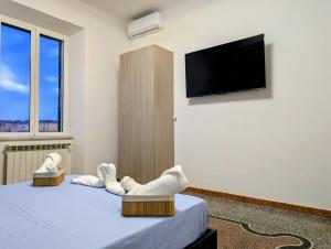 une chambre avec un lit avec deux chaises et une télévision à écran plat dans l'établissement La Casa Al Mare, à Vado Ligure