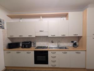 une cuisine avec des armoires blanches et un évier dans l'établissement La Casa Al Mare, à Vado Ligure 7 autres photos