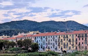 un groupe de bâtiments avec une montagne en arrière-plan dans l'établissement La Casa Al Mare, à Vado Ligure