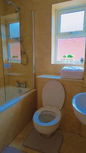 ein Badezimmer mit Toilette und Waschbecken und einem Fenster in der Unterkunft Modern luxury 3-bedroom guesthouse in Wigan in Wigan