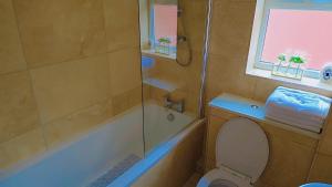 ein Badezimmer mit Badewanne, Toilette und Dusche in der Unterkunft Modern luxury 3-bedroom guesthouse in Wigan in Wigan + 34 Fotos