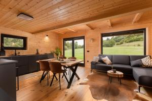 a kitchen and living room with a couch and a table at Black Cabin Lokve in Homer