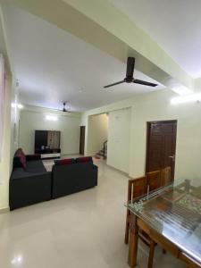 Una sala de estar con un sofá negro y una mesa. en Gavi Paradise Homestay, en Vandanmedu