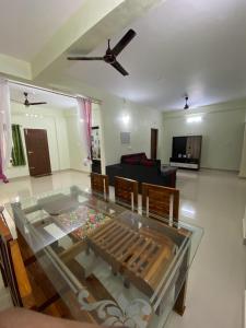 una mesa de cristal en el medio de una sala de estar en Gavi Paradise Homestay, en Vandanmedu