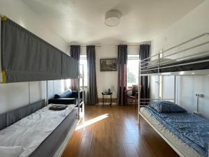 a bedroom with two bunk beds and a couch at Grums self-service house in Grums