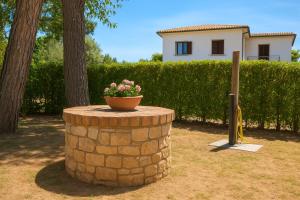 a brick barrel with a flower pot on top of it at Villa Carla accesso al mare privato posto auto riservato in Sperlonga