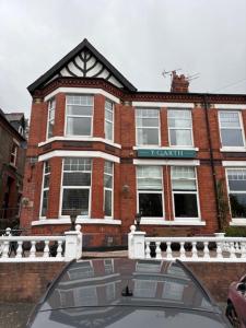 a red brick building with a glass window in front of it at Y Garth Guesthouse in Bangor