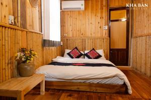 a bedroom with a bed in a room with wooden walls at Kha Bản Homestay in Cao Bằng