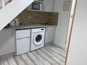 a kitchen with a washing machine and a microwave at W5 Studio in Ealing +3 photos