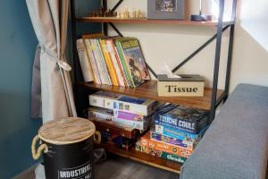 a book shelf filled with books next to a stool at Idéal pour la famille proche du Futuroscope in Jaunay-Marigny