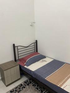 a bed sitting in a room with a box at Obah Homestay Kota Bharu in Kota Bharu
