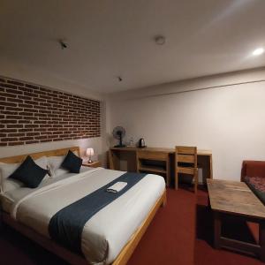 a bedroom with a bed and a desk and a chair at Sayami Home in Pātan +38 photos