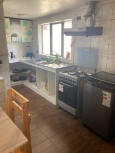 a kitchen with a stove and a sink at Precioso alojamiento centro Coyhaique in Coihaique +6 photos