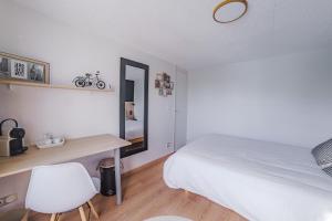 a bedroom with a bed and a desk and a mirror at Idéal pour la famille proche du Futuroscope in Jaunay-Marigny