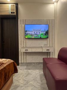 a living room with a tv on a wall at The Golden Inn in Lucknow