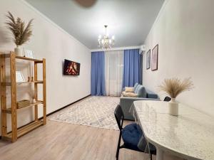 a living room with a couch and a table at Апартаменты в ЖК Ирина рядом с Баянтау in Pavlodar