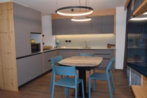 een keuken met een tafel en blauwe stoelen bij Chalet Radola in Campitello di Fassa