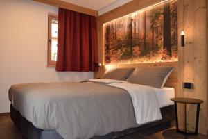 een slaapkamer met een bed met een groot raam bij Chalet Radola in Campitello di Fassa