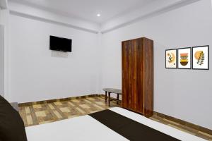 a room with a tv and a table and a chair at HOTEL O GOLDEN MAJESTIC in Prayagraj