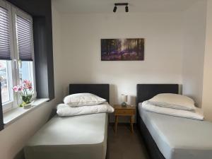 zwei Einzelbetten in einem Zimmer mit Fenster in der Unterkunft Appartement de luxe in Löhne