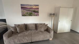 ein Wohnzimmer mit einer Couch und einem Gemälde an der Wand in der Unterkunft Appartement de luxe in Löhne
