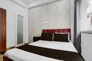 a bedroom with a large bed with a red headboard at HOTEL O GOLDEN MAJESTIC in Prayagraj