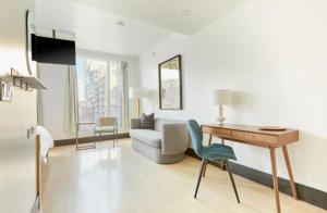 ein Wohnzimmer mit Schreibtisch und Sofa in der Unterkunft The Beverley Hotel in Toronto