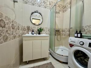 a bathroom with a sink and a washing machine at Уютная квартира рядом с Батырмол in Pavlodar