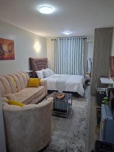 a hotel room with a bed and a couch at Staycation with Ryn in Ruaka