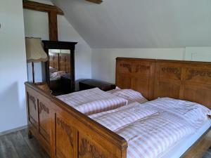 - une chambre avec un grand lit en bois et un miroir dans l'établissement Chalupa u ztraceného potoka, à Vernířovice
