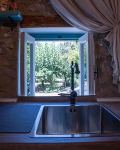 a kitchen sink in front of a window at Prastio Urban Houses 