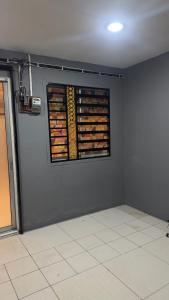a room with a wall with a window filled with donuts at Plus Home Stay in Kulai
