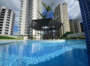 a large swimming pool with a pavilion in front of buildings at Edifício Panoramique 180 Graus, Cobertura in Guarujá