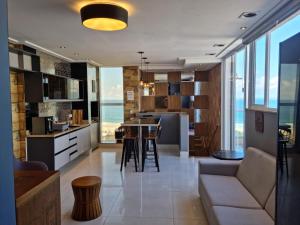 a kitchen and living room with a view of the ocean at Edifício Panoramique 180 Graus, Cobertura in Guarujá