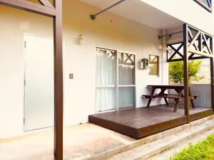 a porch of a house with a table on it at CASA de RandN Nakama 1F in Onna