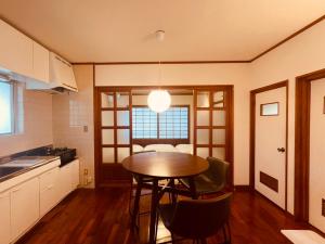 a kitchen with a table and chairs in a room at CASA de RandN Nakama 1F in Onna +10 photos