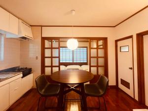 a kitchen with a table and chairs in a room at CASA de RandN Nakama 1F in Onna
