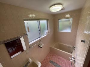 a bathroom with a tub and a sink at CASA de RandN Nakama 1F in Onna