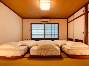 a room with four beds in it with a window at CASA de RandN Nakama 1F in Onna