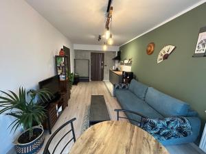 a living room with a blue couch and a table at Garden Spot and Parking in Krakow