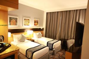 a hotel room with two beds and a television at فندق برستيج اجياد in Ajyad