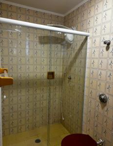 a bathroom with a shower with a glass door at Apartamento Centro Serra Negra in Serra Negra