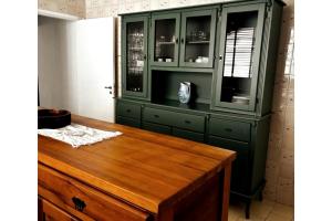 a green cabinet with a wooden table in a room at Apartamento Centro Serra Negra in Serra Negra