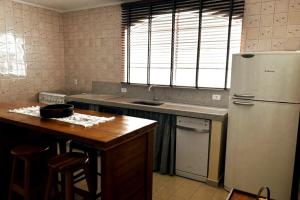 a kitchen with a refrigerator and a table in it at Apartamento Centro Serra Negra in Serra Negra +5 photos