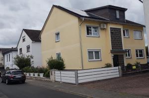 a yellow house with a car parked in front of it at Apartment Laurence in Hanau am Main